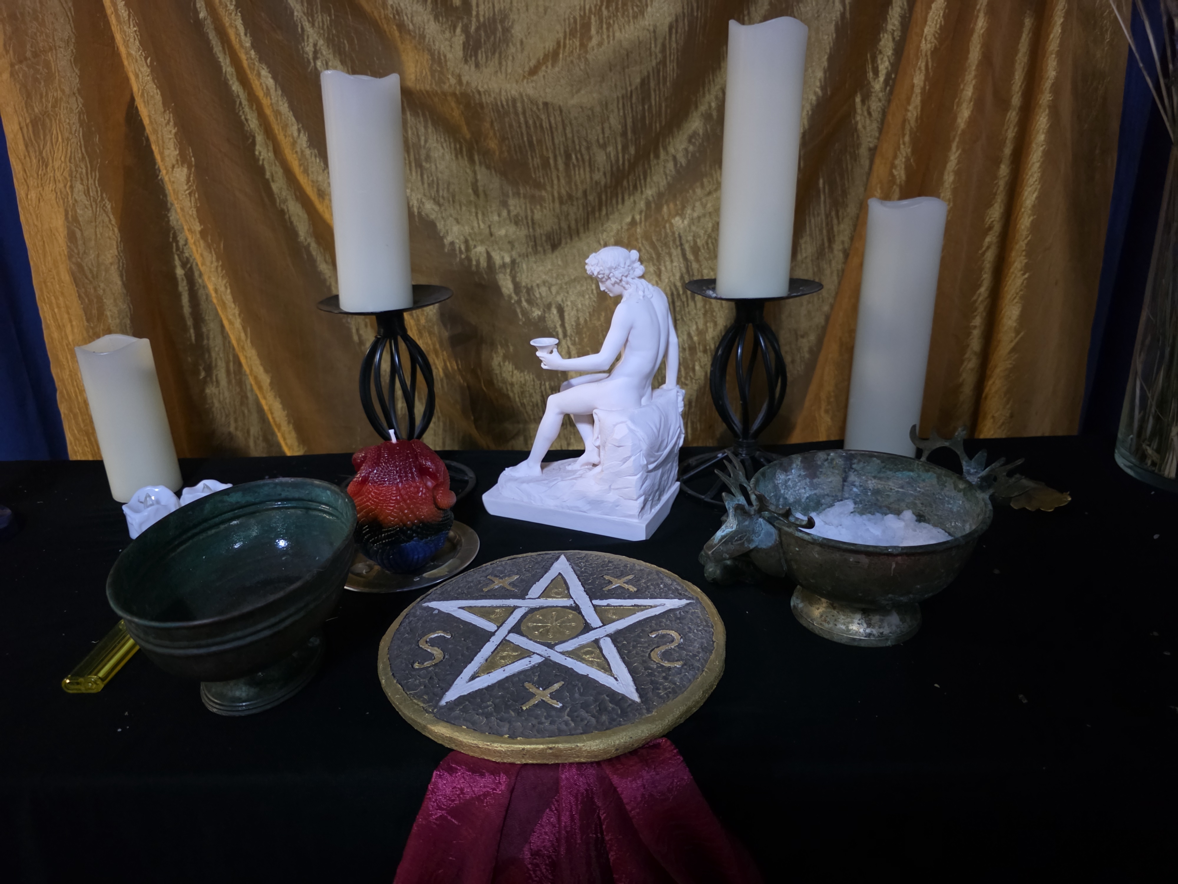 Altare wiccan con pentacolo, candele e simboli rituali